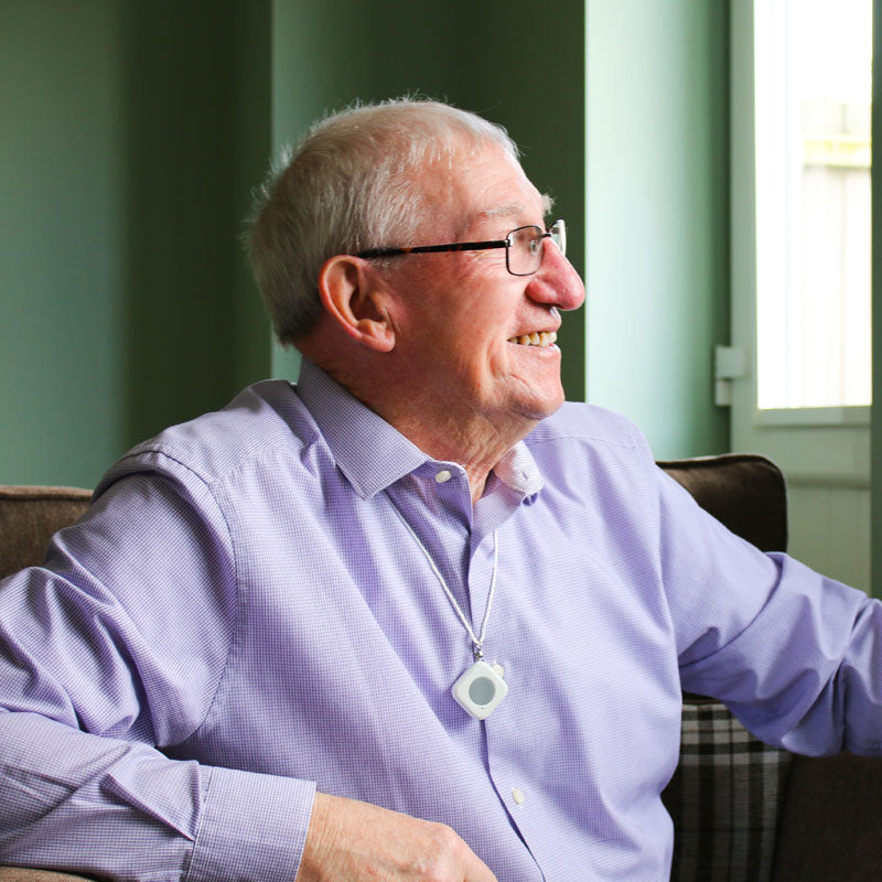 Man looking out of the window whilst wearing SmartLife neck pendant